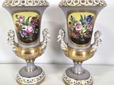 two vases with flowers painted on them sitting on a table