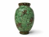 un vase vert posé sur une surface blanche, sur fond blanc
