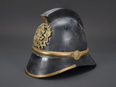 un vieux casque orné d'un motif doré sur le côté
