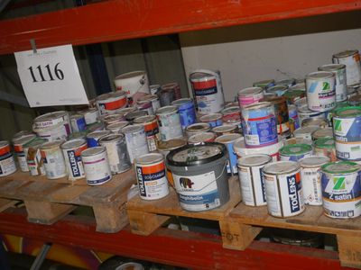 de nombreux pots de peinture sur une palette dans un entrepôt