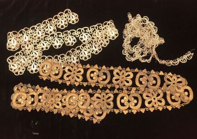a group of gold jewelry on a black surface