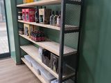 une étagère sur laquelle sont posées des bouteilles et des canettes, dans un coin de la pièce