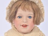 a doll that is sitting on the ground with a hat on