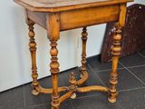 a small table with a wooden top on a tiled floor