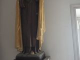 une statue représentant une femme tenant un oiseau, posée sur un socle