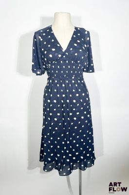 La robe est bleue et blanche, avec des pois.