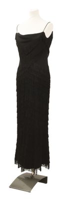 une robe noire sur un mannequin, posée sur un fond blanc