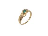 gros plan d'une bague en or avec une pierre verte