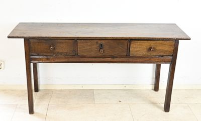 an old wooden table with three drawers on top of it