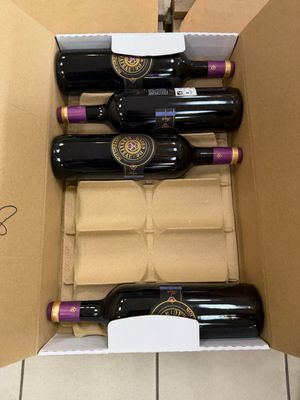 six bouteilles de vin dans un carton posé par terre
