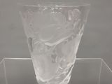 un vase en verre transparent posé sur une étagère transparente, sur fond blanc