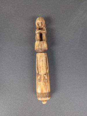 une vieille figurine en bois représentant une femme tenant un enfant dans ses bras