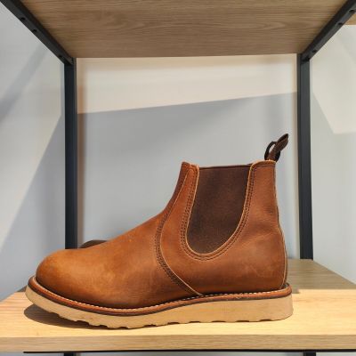 une paire de bottes marron posée sur une étagère en bois