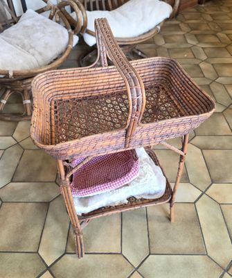 a wicker baby carriage with a basket on top of it