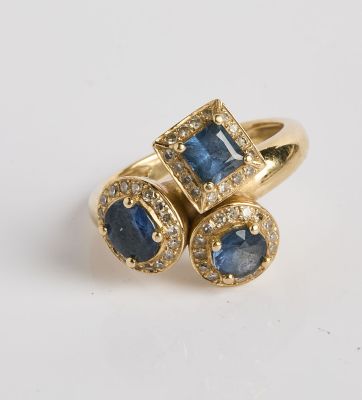 gros plan d'une bague en or avec saphirs bleus et diamants