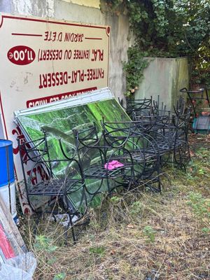 un tas de chaises et de tables devant un bâtiment