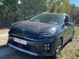 un SUV noir garé sur un chemin de terre devant des arbres