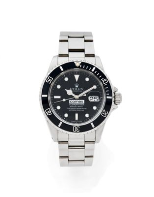un gros plan d'une montre sur une surface blanche avec un fond blanc