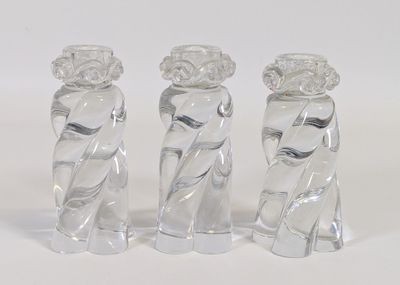 trois vases en verre posés sur une surface blanche