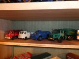 de nombreux camions miniatures sur une étagère dans une pièce