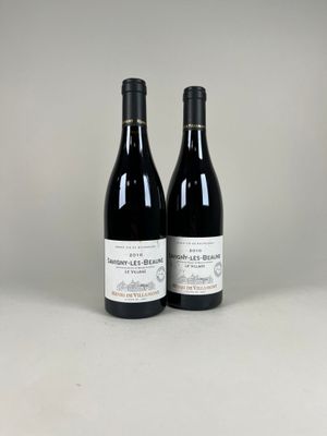 deux bouteilles de vin posées sur une table blanche