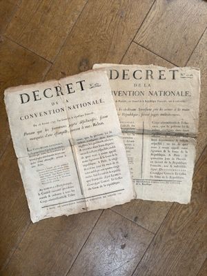 two old newspapers sitting on a wooden floor next to a pair of scissors