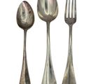 three spoons and a fork sitting next to each other