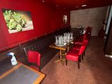 tables and chairs in a room with red walls and a picture on the wall