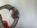 someone is holding a wrist watch with a chain around it