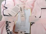 a pink dress with black trims and a tag on it