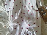 a pile of baby clothes that are laying on a bed