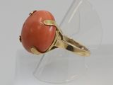 an image of a ring with a coral colored stone in it