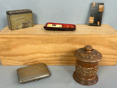 une petite boîte en bois contenant un briquet et un étui à briquet