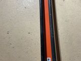 an orange pipe cutter sitting on top of a floor next to a pair of shoes