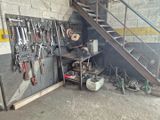 de nombreux outils accrochés au mur près d'un escalier