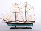 a model of a sailboat on a wooden stand