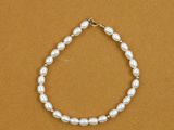 a white pearl bracelet on a brown background