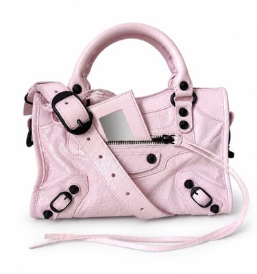 a small pink purse with a mirror on it