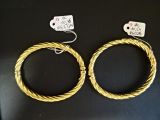 deux bracelets en fil métallique doré posés sur une surface noire