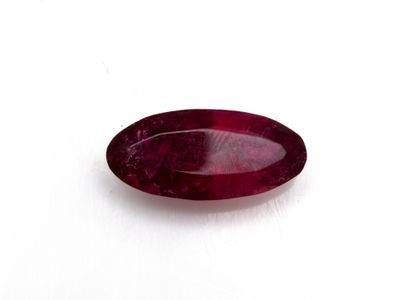 a close up of a red ruby gems on a white surface
