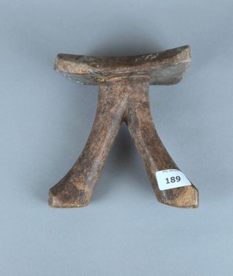 un petit tabouret en bois sur lequel est accrochée une étiquette