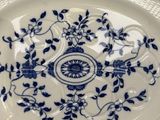 a blue and white plate with a flower design on it