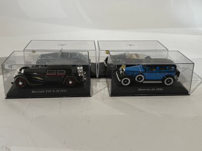 two model cars in a display case on a white surface