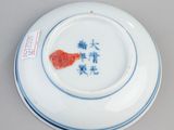 a white plate with a blue and red design on it