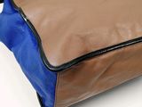 a brown and blue bag sitting on a white surface