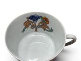 a white cup with a bird design on it