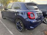 the rear end of a small blue car parked in a parking lot