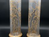 deux vases ornés de motifs dorés, posés sur une surface noire
