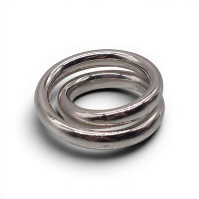 une bague en argent posée sur une surface blanche, sur fond blanc