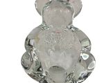 a glass teddy bear sitting on top of a glass plate